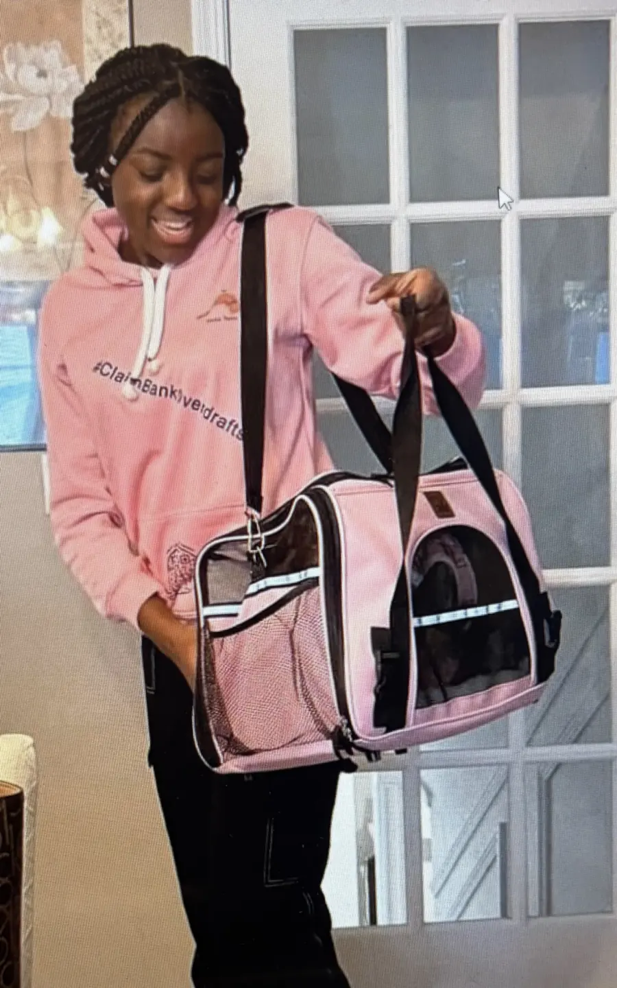 Young woman wearing the pink #ClaimBankOverdrafts hoodie